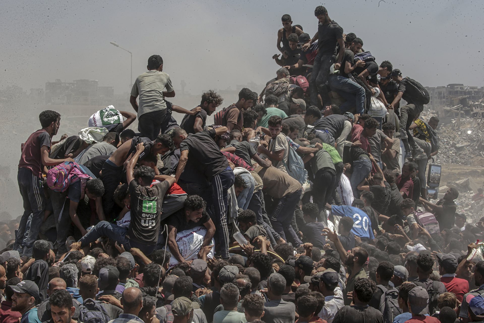 Palestinians climb onto an aid truck as it enters the Gaza Strip via the Zikim Crossing in an attempt to get flour, during what the Israeli military called a &ldquo;tactical suspension&rdquo; in operations to allow humanitarian aid through.